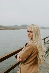 Portrait of a young blonde woman by a foggy river in Minsk, Belarus.